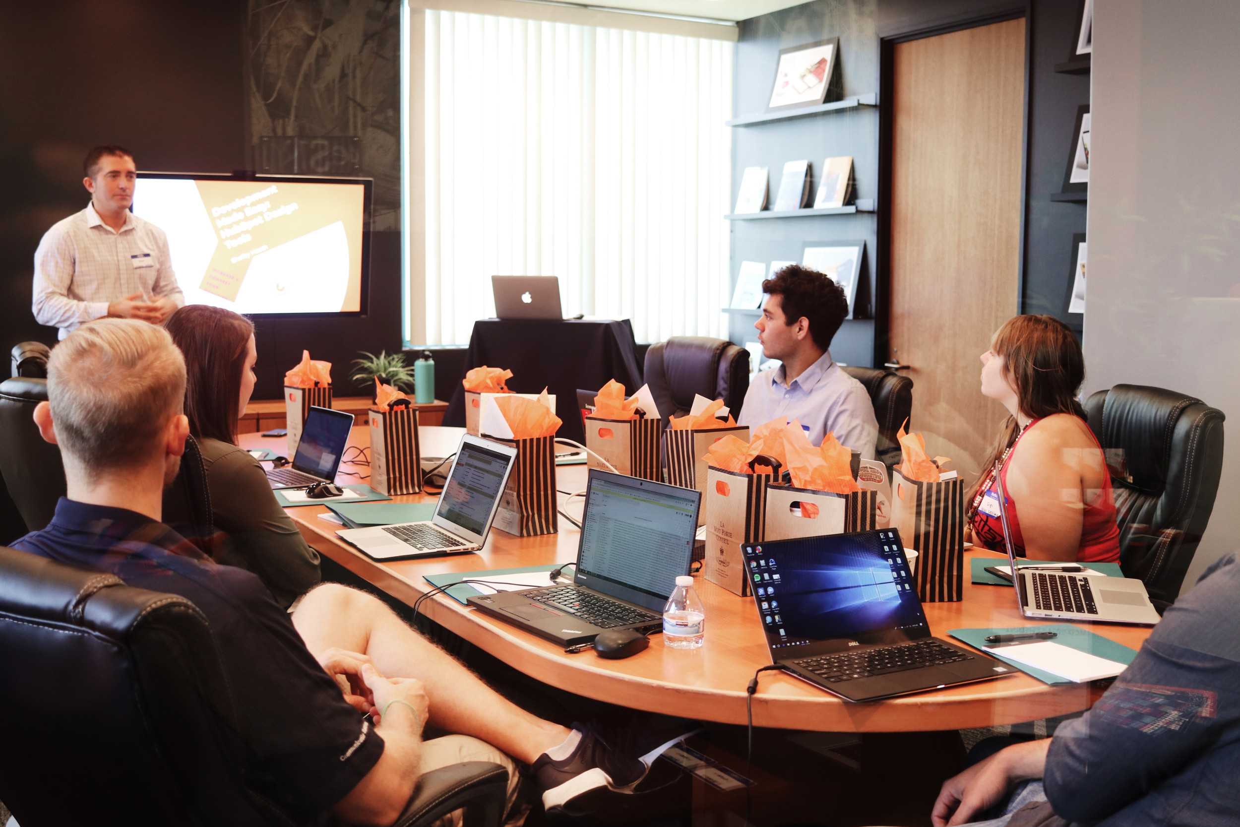 people sitting at table listening to presentation