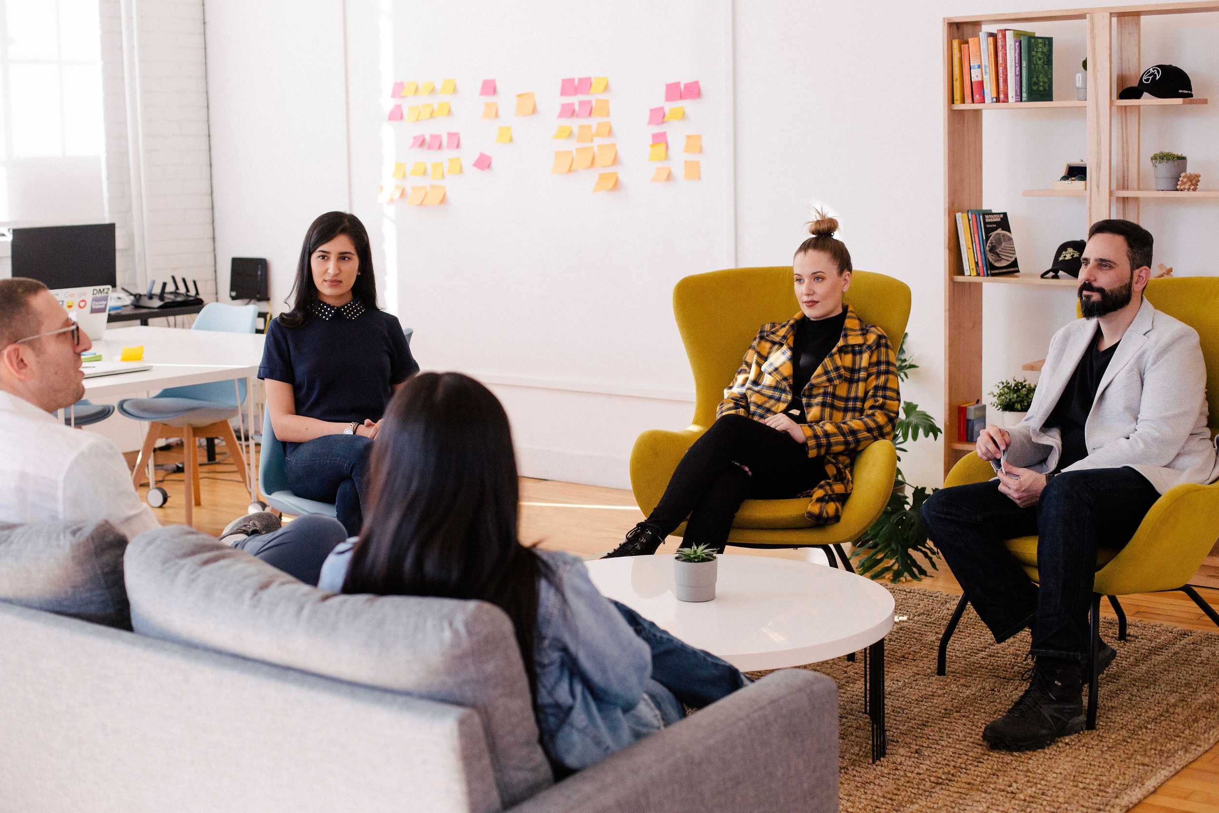 people seated on couch and chairs around coffee table